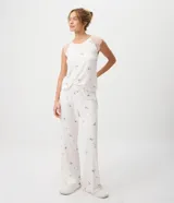 Pijama de dos piezas de viscolycra blanca con estampado floral y detalles de encaje en los hombros. Incluye una musculosa de escote redondo y un pantalón largo de corte recto.