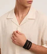Kit de seis pulseras masculinas de color negro con distintos diseños, incluyendo modelos trenzados con cierre ajustable y modelos de cuentas de madera y vidrio.