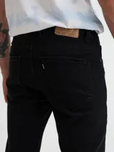 Pantalón de jean negro, corte ajustado.