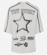 Remera de algodón color crema con cuello redondo y mangas cortas con costuras desplazadas en contraste. Presenta un estampado frontal grande con los personajes de la película Toy Story.