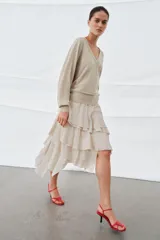 Jersey de lana color beige, con escote en pico y manga larga.