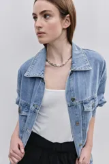 Campera de jean de silueta amplia, con cuello clásico y cierre frontal con botones. Diseño con bolsillos con solapa en el frente y bolsillos laterales, hombros caídos y terminaciones pespunteadas.