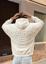 Buzo con capucha de color off-white, con diseño de letras en relieve en la espalda que forman la palabra 'littlestars'. Presenta puños y ruedo acanalados.