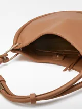 Bolso hobo color marrón claro, con textura napa y asa tubular con pieza metálica. Tiene un compartimento con cierre de clip magnético y un bolsillo interior con cremallera.