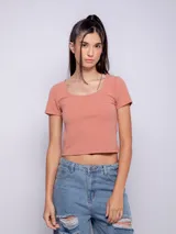 Remera color salmón elastizada de manga corta y cuello redondo.