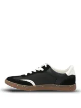 Championes urbanos de diseño deportivo en color negro, con paneles de gamuza sintética y material textil. Presentan detalles en blanco en el talón, cordones y borde frontal, con suela de goma tipo caramelo con efecto moteado.