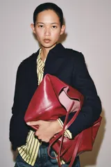 Bolso tipo shopper de cuero en color bordó, con diseño amplio y asas largas para el hombro.