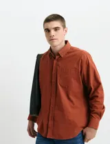 Camisa de franela lisa con cuello button-down, manga larga, botones al tono y bolsillo frontal en el pecho.