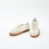 Zapatillas deportivas bajas de estilo retro, color blanco con detalles en tono crema y suela de goma color caramelo. Presentan cierre con cordones y puntera reforzada con diseño dentado.