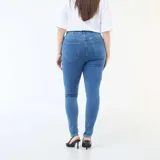 Pantalón de jean estilo skinny, de tiro muy alto con cierre frontal de botones expuestos. Presenta un lavado azul clásico y ajuste ceñido en las piernas.