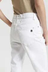 Pantalón de jean blanco, corte mom fit, tiro alto y costuras color camel a contratono.