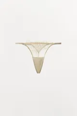 Tanga de tiro medio confeccionado en encaje suave con detalles de bordados florales a tono y cintura elástica.
