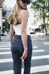 Pantalón jeans Z1975 de tiro alto y diseño mom fit, color azul claro con lavado desgastado, de corte tobillero y cinco bolsillos. Cierre frontal con cremallera y botón metálico.