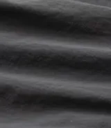 Bermuda cargo negra de tejido tecnológico (poliamida), con corte holgado, bolsillos laterales funcionales y cintura elástica con cordón ajustable.