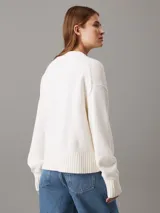 Sweater blanco de punto con cuello redondo y logo de Calvin Klein bordado en el cuello.
