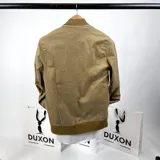 Campera bomber color mostaza confeccionada en gabardina, con cuello, puños y ruedo acanalados. Cierre frontal con cremallera y bolsillos laterales.