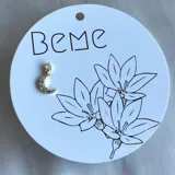 Aro dorado con forma de luna creciente y pequeños brillantes incrustados.