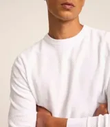 Buzo de hombre con cuello redondo, corte comfort, manga larga con puños ajustados y tejido texturizado.