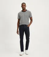 Pantalón de corte slim confeccionado en tejido de sarga de algodón con un toque de elastano. Presenta cierre de botón y cremallera, trabillas en la cintura y bolsillos laterales y traseros.