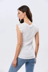 Remera de algodón azul melange con escote redondo y mangas cortas adornadas con doble volado de broderie en los hombros.