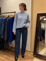 Buzo de punto en color celeste, con cuello alto y diseño de tramado trenzado en el frente y mangas. Posee un corte holgado con mangas largas y terminaciones acanaladas.