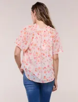 Blusa blanca de doble capa de gasa con estampado floral en tonos amarillos, celestes y rosados, escote en V con frunces y mangas cortas con volados amplios.