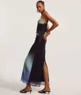 Vestido largo de tirantes finos, con escote recto y detalle fruncido lateral. Presenta un estampado abstracto con manchas difuminadas en tonos azul, verde y negro.