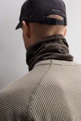 Camiseta relaxed fit de color verde militar, confeccionada en tejido con estructura waffle. Tiene cuello redondo, manga larga con puño elástico y un bolsillo plastrón con cierre de cremallera en el pecho.