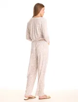 Conjunto de pijama compuesto por una remera de mangas largas con escote redondo y bolsillo frontal, y un pantalón largo con cintura elástica. Ambas piezas presentan un estampado floral y detalles de apliques de crochet en el cuello y el bolsillo.