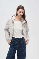 Campera acolchada de color beige con diseño capitoneado en forma de rombos, cierre frontal completo y capucha integrada.