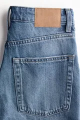 Bermuda de cinco bolsillos en denim de algodón, de tiro alto con cierre de botones y detalles de roturas.