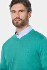 Sweater de hilo color borgoña, con cuello en V y logo bordado en el pecho.