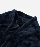 Bata de baño masculina confeccionada en fleece texturizado, con cuello solapa, mangas largas, lazo ajustable en la cintura y bolsillos delanteros.