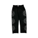 Pantalón de jogging negro con diseño de círculos con rayos decorados con pedrería brillante a lo largo de ambas piernas. Cuenta con cintura elástica con cordón ajustable.