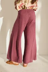 Pantalón ancho negro de lino con cintura elástica y detalles de flecos en los laterales.