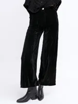 Pantalón palazzo negro de terciopelo con botón dorado.