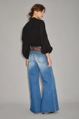 Jean palazzo de tiro alto, color azul claro con efecto desgastado, y corte holgado.