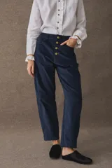 Pantalon de corte barrel en pana azul marino, con cierre frontal de botones dorados a la vista y costuras reforzadas en las rodillas.