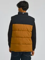 Chaleco acolchado Caterpillar modelo Arctic Zone Vest, de diseño bicolor en negro y tostado, con cierre frontal de cremallera y cuello alto.