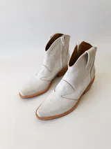 Botas texanas de cuero color gris claro, con caña baja, puntera cuadrada y taco de madera.