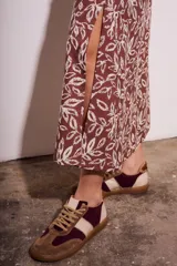 Falda midi marrón con estampado de hojas en color crema y abertura lateral.