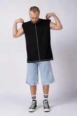 Musculosa oversize de algodón estilo sudadera, color crudo, con costuras visibles en contraste en color negro que recorren el centro verticalmente y enmarcan el cuello y el ruedo.