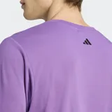 Remera violeta de corte clásico con logo Adidas estampado en el frente con diseño de siluetas humanas en negro y blanco.