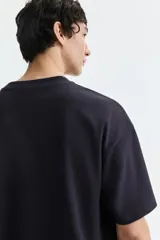 Remera oversize color negro de algodón con cuello redondo y mangas cortas amplias.
