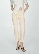 Jeans estilo flare color beige, confeccionados en tejido elástico de algodón. Presentan diseño crop, tiro alto, cinco bolsillos, trabillas para cinturón y cierre frontal con cremallera y botón. Los dobladillos tienen terminación deshilachada.