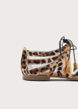 Ballerinas planas con diseño de rejilla y estampado animal print, con detalles de tiras cruzadas y borlas en el empeine.