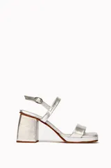 Sandalias plateadas de cuero vacuno, con dos tiras horizontales en el empeine y tobillo, ajuste con hebilla, plataforma delantera y tacón cuadrado.