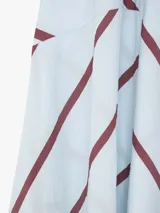 Vestido largo de viscosa con diseño asimétrico, tirantes finos, escote en V y estampado de líneas diagonales amarillas sobre fondo rosado.