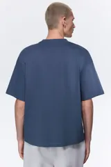 Remera de punto de algodón con corte oversized, cuello redondo acanalado y diseño de hombros caídos.