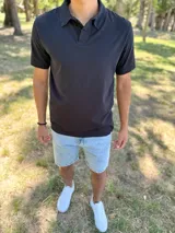 Remera polo de manga corta en color negro, con cuello camisero y cierre frontal de botones.